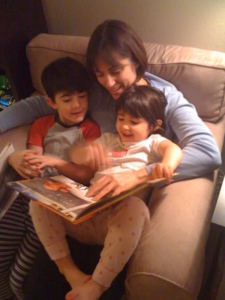 Karen Pery smiling as she reads to children