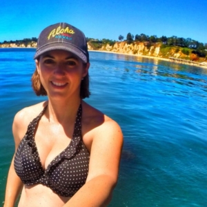 Karen Pery smiling in the water wearing a Hawaii hat