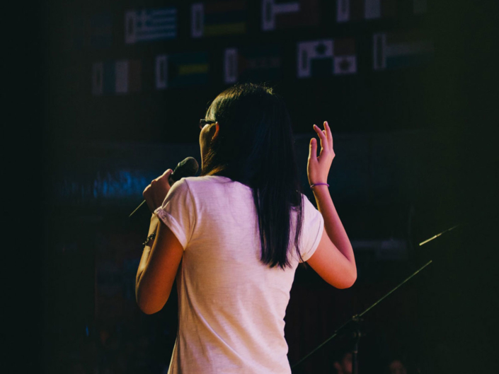 Born Leader a speaker holding a microphone and speaking at FEAT