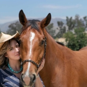 Karen Pery standing beside a gentle horse